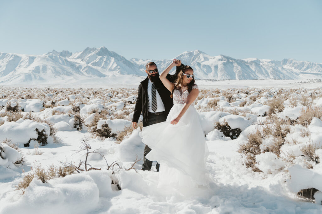 Groom twirls bride around in the snow outside mammoth lakes california