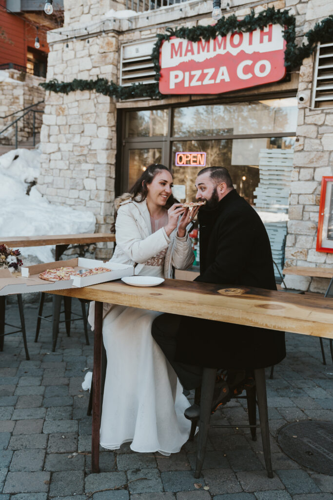 Bride feeds pizza to groom in Mammoth Lakes California
