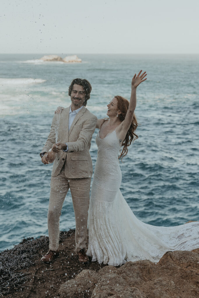 Bride and groom celebrate their elopement in Big Sur by popping champagne 
